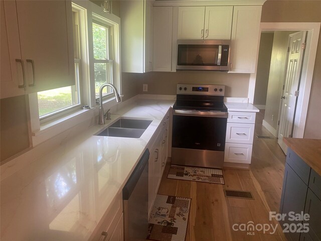 103 Hickory Hills Dr, Morganton, NC 28655 - kitchen with appliances with stainless steel finishes, light wood finished floors, and white cabinetry