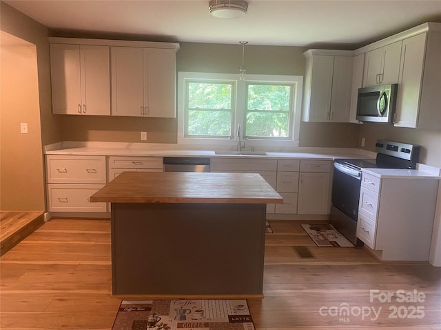 103 Hickory Hills Dr, Morganton, NC 28655 - kitchen with appliances with stainless steel finishes, light wood-style flooring, butcher block countertops, and a kitchen island