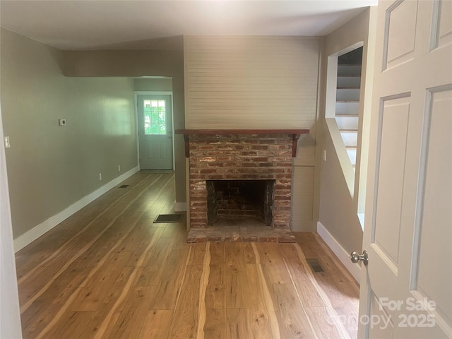 103 Hickory Hills Dr, Morganton, NC 28655 - unfurnished living room with light wood finished floors and a brick fireplace