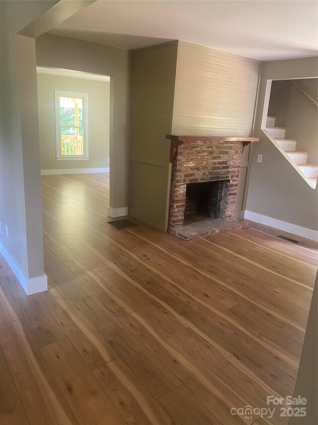 103 Hickory Hills Dr, Morganton, NC 28655 - unfurnished living room with wood-type flooring, a fireplace, and stairs