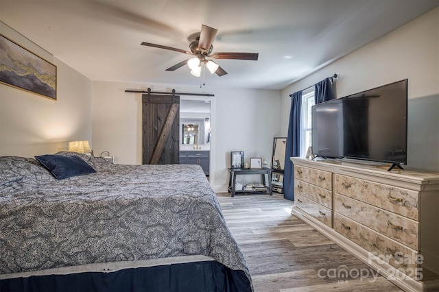 110 Camelot Dr, Granite Falls, NC 28630 - bedroom with a barn door, wood finished floors, ceiling fan, and connected bathroom