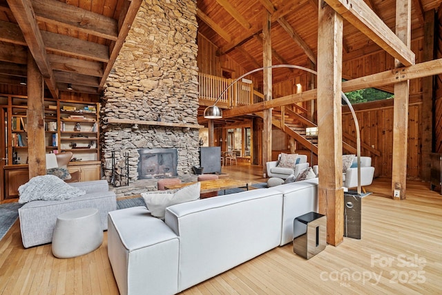 574 Locust Grove Dr, Waynesville, NC 28785 - living room featuring a wood ceiling with exposed beams, hardwood / wood-style floors, a stone fireplace, high vaulted ceiling, and wooden walls