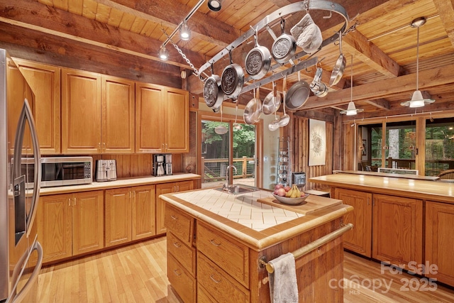 574 Locust Grove Dr, Waynesville, NC 28785 - kitchen with a wooden ceiling with exposed beams, appliances with stainless steel finishes, tile countertops, light wood finished floors, and a kitchen island with sink