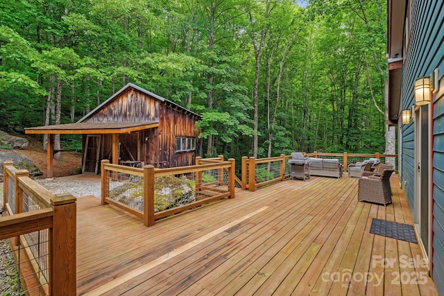 574 Locust Grove Dr, Waynesville, NC 28785 - wooden terrace with outdoor lounge area, a view of trees, area for grilling, and an outdoor structure
