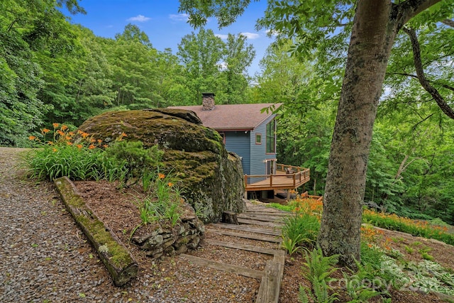 574 Locust Grove Dr, Waynesville, NC 28785 - view of front of home with a chimney, a wooden deck, a view of trees, and roof with shingles