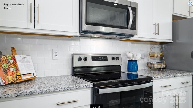 233 Paige Rd, Kings Mountain, NC 28086 - kitchen featuring appliances with stainless steel finishes, decorative backsplash, white cabinetry, and light stone counters