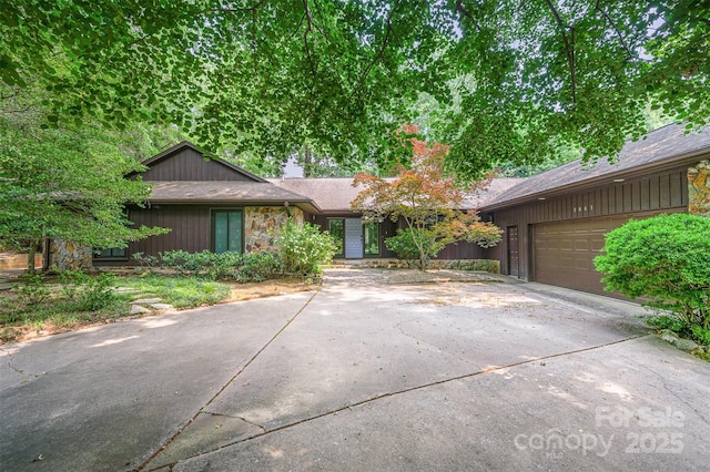 3041 Shallowood Ln, Charlotte, NC 28277 - mid-century home with concrete driveway, an attached garage, a chimney, and a shingled roof