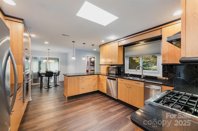 3041 Shallowood Ln, Charlotte, NC 28277 - kitchen with appliances with stainless steel finishes, a peninsula, dark wood-style floors, light brown cabinetry, and under cabinet range hood
