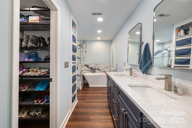 3041 Shallowood Ln, Charlotte, NC 28277 - bathroom featuring double vanity, a walk in closet, wood finished floors, a soaking tub, and a shower