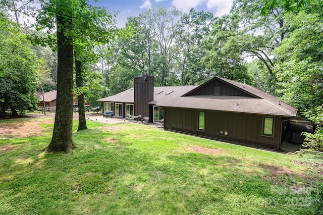 3041 Shallowood Ln, Charlotte, NC 28277 - back of property featuring a chimney, a yard, a shingled roof, a patio area, and view of wooded area