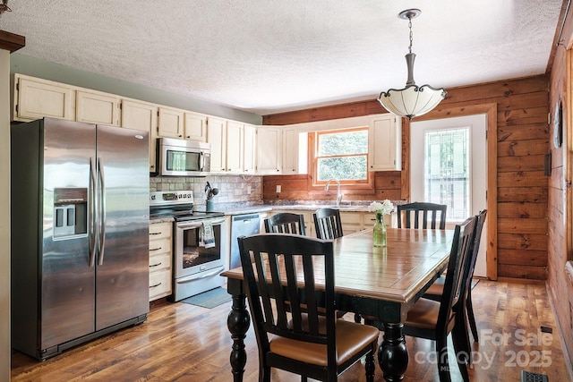 2266 Sugar Mountain Rd, Newland, NC 28657 - dining room with a textured ceiling, light wood finished floors, and wood walls