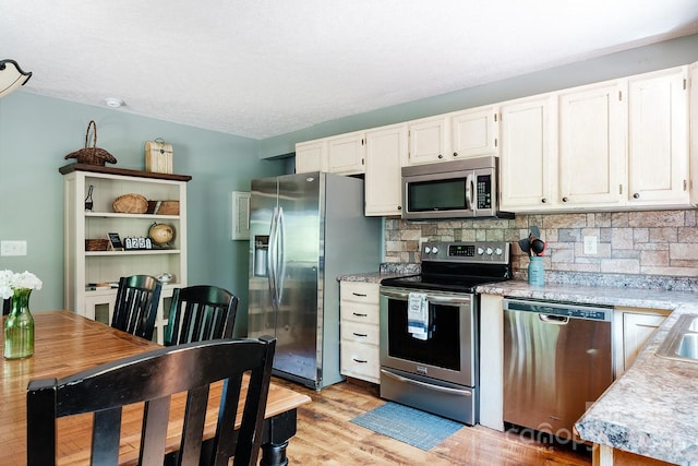 2266 Sugar Mountain Rd, Newland, NC 28657 - kitchen with appliances with stainless steel finishes, light countertops, light wood finished floors, and tasteful backsplash