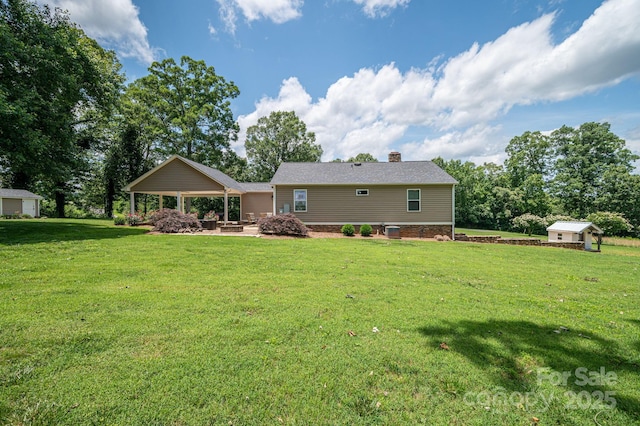 4441 Jim Wise Rd, Lincolnton, NC 28092 - back of property featuring a storage shed, a lawn, a chimney, a gazebo, and a patio area