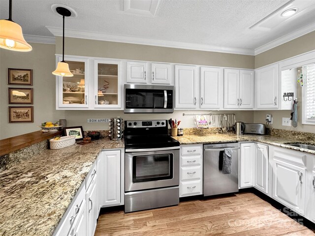 87 Willow Rd Unit D-4, Waynesville, NC 28786 - kitchen with appliances with stainless steel finishes, crown molding, white cabinets, a textured ceiling, and glass insert cabinets