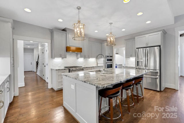 2122 Goose Creek Farm Ln, Indian Trail, NC 28079 - kitchen featuring stainless steel appliances, backsplash, light stone countertops, a chandelier, and a center island with sink