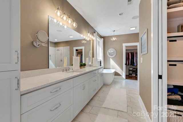 2122 Goose Creek Farm Ln, Indian Trail, NC 28079 - bathroom featuring a walk in closet, double vanity, a stall shower, marble look tiles, and a freestanding tub