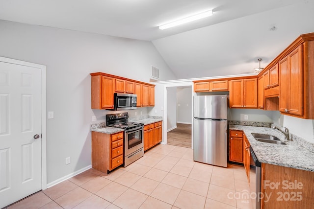 9000 Vagabond Rd, Charlotte, NC 28227 - kitchen with stainless steel appliances, light tile patterned flooring, lofted ceiling, light stone counters, and brown cabinets