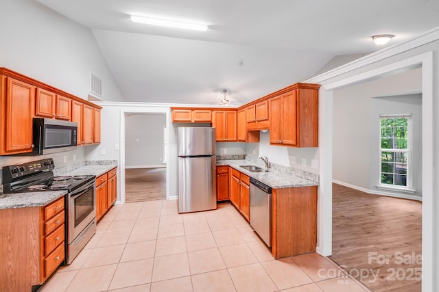 9000 Vagabond Rd, Charlotte, NC 28227 - kitchen with appliances with stainless steel finishes, vaulted ceiling, light stone counters, ceiling fan, and light tile patterned floors