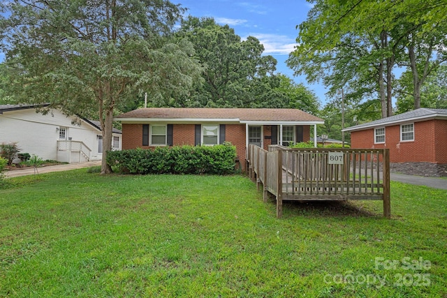 807 Claremont Rd, Charlotte, NC 28214 - view of front of home with a front lawn, brick siding, and a deck