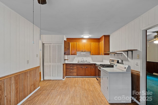 807 Claremont Rd, Charlotte, NC 28214 - kitchen with washer / clothes dryer, brown cabinets, a ceiling fan, light countertops, and wooden walls