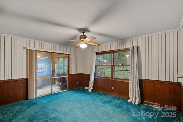 807 Claremont Rd, Charlotte, NC 28214 - carpeted empty room with wallpapered walls, ceiling fan, a wainscoted wall, and ornamental molding