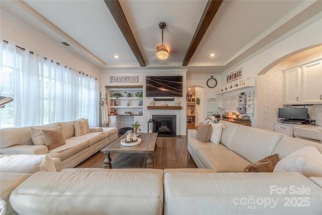1178 Arges River Dr, Fort Mill, SC 29715 - living area featuring arched walkways, wood finished floors, beamed ceiling, a fireplace, and ornamental molding