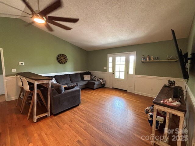 8122 Hutchison Ln, Vale, NC 28168 - living area with a ceiling fan, a wainscoted wall, a textured ceiling, wood finished floors, and vaulted ceiling