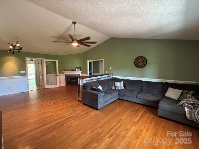 8122 Hutchison Ln, Vale, NC 28168 - living area featuring ceiling fan, wood finished floors, lofted ceiling, a fireplace, and a textured ceiling