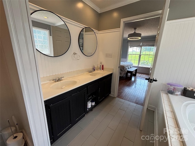 8122 Hutchison Ln, Vale, NC 28168 - bathroom featuring double vanity, connected bathroom, wood finished floors, ornamental molding, and a tub