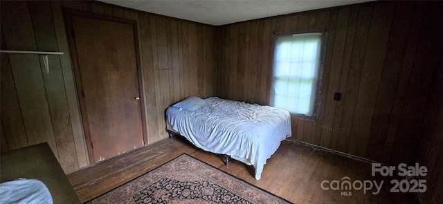 127 Hibriten Mountain Rd, Lenoir, NC 28645 - bedroom with wooden walls, wood finished floors, and multiple windows