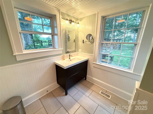5188 Dysartsville Rd, Morganton, NC 28655 - bathroom featuring vanity, healthy amount of natural light, a wainscoted wall, tile patterned floors, and wooden walls