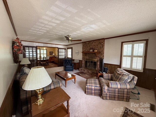 200 Breslin St, Wadesboro, NC 28170 - living room featuring ornamental molding, wainscoting, a textured ceiling, carpet flooring, and a ceiling fan