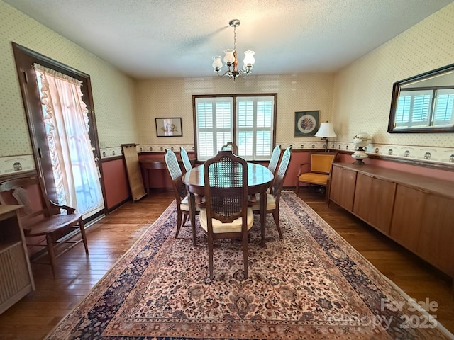 200 Breslin St, Wadesboro, NC 28170 - dining space featuring wallpapered walls, a chandelier, wood-type flooring, and a textured ceiling