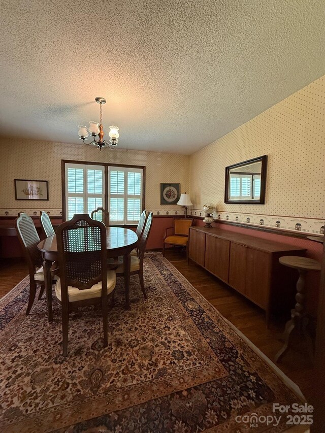 200 Breslin St, Wadesboro, NC 28170 - dining area with wallpapered walls, a chandelier, dark wood-type flooring, and a textured ceiling