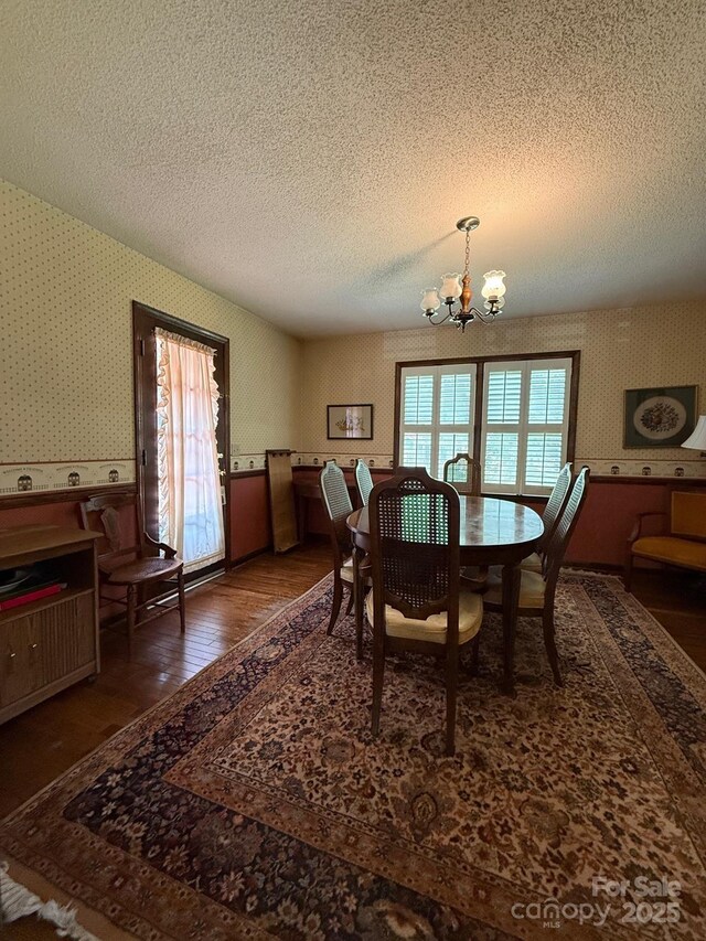 200 Breslin St, Wadesboro, NC 28170 - dining space with wallpapered walls, a textured ceiling, wood finished floors, and a chandelier