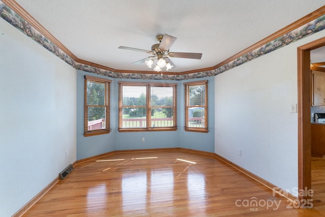 5211 Spring Gln, York, SC 29745 - spare room featuring crown molding, light wood-style flooring, ceiling fan, and a textured ceiling