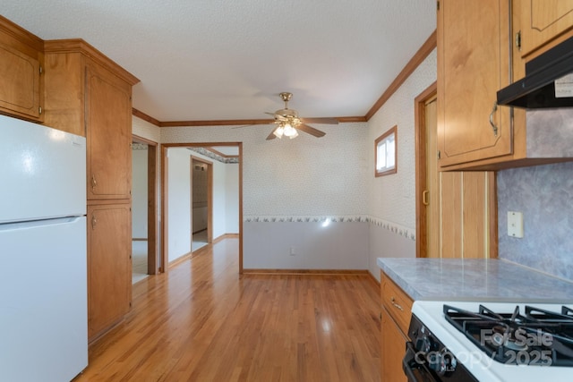 5211 Spring Gln, York, SC 29745 - kitchen featuring freestanding refrigerator, crown molding, wallpapered walls, under cabinet range hood, and light wood-type flooring