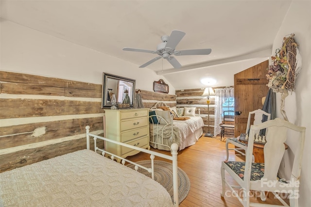 189 Woodstock Dr, West Jefferson, NC 28694 - bedroom featuring light wood-style floors, lofted ceiling, a ceiling fan, and wooden walls