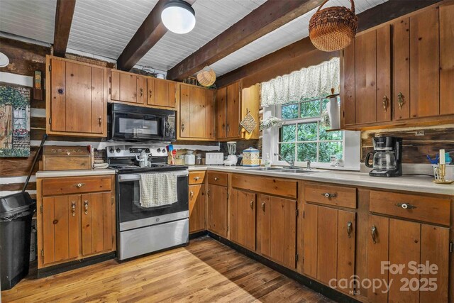 189 Woodstock Dr, West Jefferson, NC 28694 - kitchen featuring stainless steel electric range, black microwave, beamed ceiling, light countertops, and light wood-type flooring