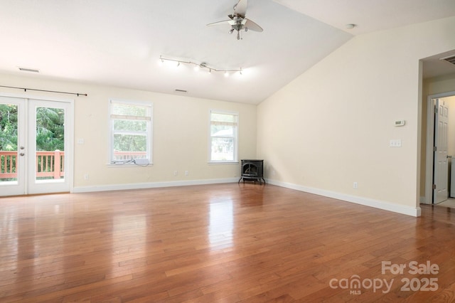 29 Honey Hollow Ln, Fairview, NC 28730 - unfurnished room featuring light wood finished floors, a wood stove, ceiling fan, lofted ceiling, and french doors