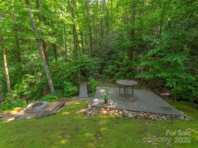 1131 Laurel Branch Rd, Waynesville, NC 28785 - view of grassy yard with a deck, a view of trees, and a fire pit