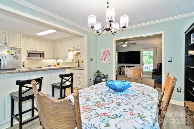 3092 Hitching Post Ln, Rock Hill, SC 29732 - dining area with a chandelier, crown molding, a ceiling fan, and light wood-style floors