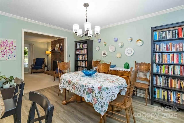 3092 Hitching Post Ln, Rock Hill, SC 29732 - dining room with a chandelier, ornamental molding, wood finished floors, and a brick fireplace