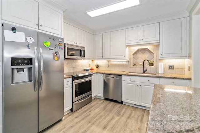 3092 Hitching Post Ln, Rock Hill, SC 29732 - kitchen featuring stainless steel appliances, white cabinetry, light wood-type flooring, and backsplash
