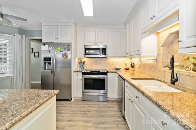 3092 Hitching Post Ln, Rock Hill, SC 29732 - kitchen featuring stainless steel appliances, white cabinetry, light wood finished floors, a ceiling fan, and ornamental molding