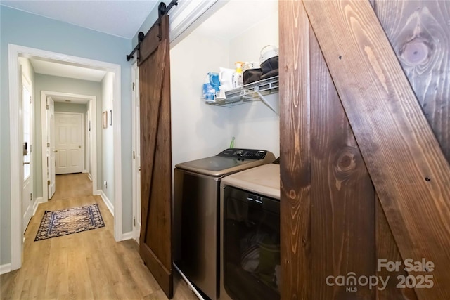 3092 Hitching Post Ln, Rock Hill, SC 29732 - laundry area with washing machine and clothes dryer, a barn door, and light wood finished floors