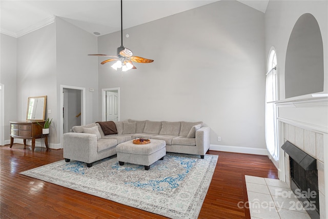 4605 Sarandon Ct, Charlotte, NC 28215 - living area featuring high vaulted ceiling, ceiling fan, dark wood-type flooring, arched walkways, and a tiled fireplace