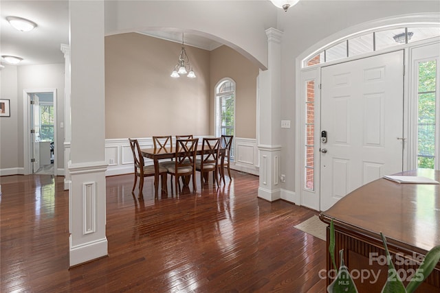 4605 Sarandon Ct, Charlotte, NC 28215 - foyer entrance featuring healthy amount of natural light, dark wood-style flooring, arched walkways, wainscoting, and a decorative wall