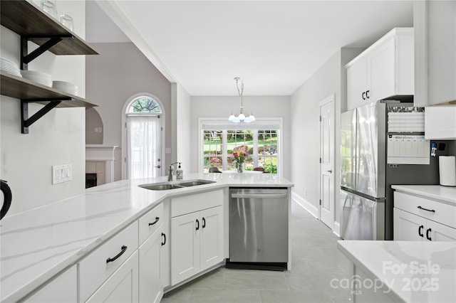 4605 Sarandon Ct, Charlotte, NC 28215 - kitchen featuring stainless steel appliances, white cabinets, light tile patterned flooring, a tiled fireplace, and light stone countertops