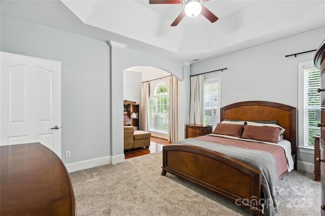 4605 Sarandon Ct, Charlotte, NC 28215 - carpeted bedroom with arched walkways, a raised ceiling, and multiple windows